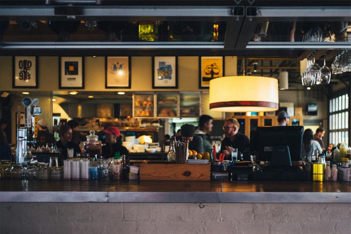 A café counter at the end of the lunch rush, staff working behind it